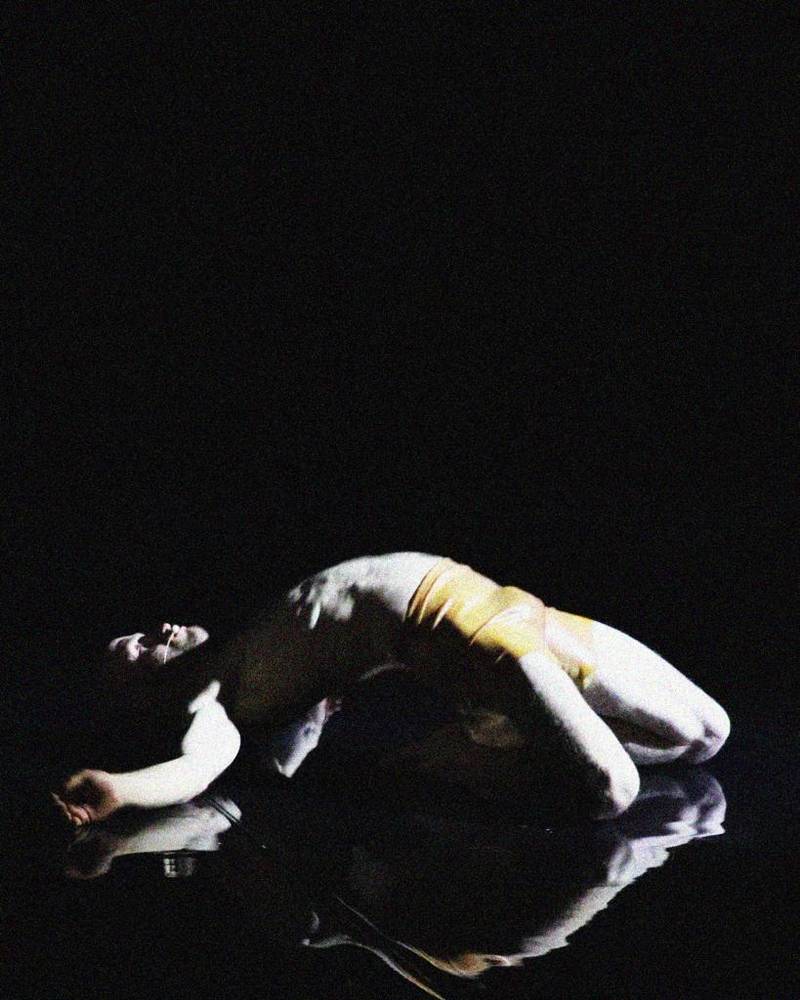 Liam Warren se tord sur le dos dans la performance « Breathing »